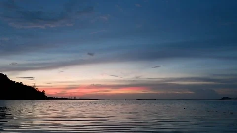 Dramatic sunset and blue sky with silhouette of mountain over calm water sea  Vídeos de archivo 94386508