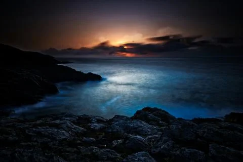 Dramatic Sunset Behind Clouds, Looking Out To Sea, With Headland Stock Photos