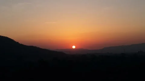 Dramatic sunset behind silhouetted mountains with orange sky Stock Footage 341076905