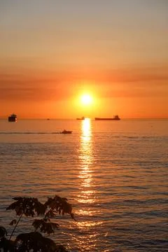 Dramatic sunset with cargo ships on horizon Stock Photos