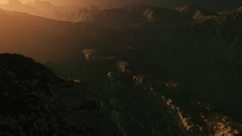 Dramatic Sunset Casts Golden Light Over Rugged Mountain Landscape Stock Footage 348824557