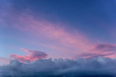 Dramatic sunset with clouds and pink orange blue sky Stock Photos