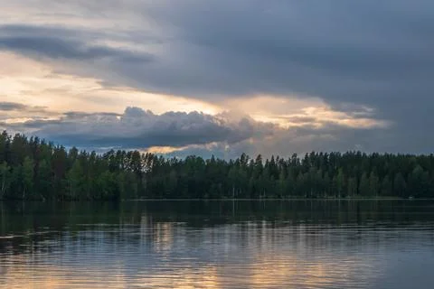 Dramatic sunset clouds on beautiful lake scenery. Stock Photos