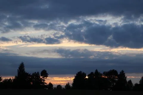 Dramatic sunset clouds dark cloudy tree silhouette Stock Photos