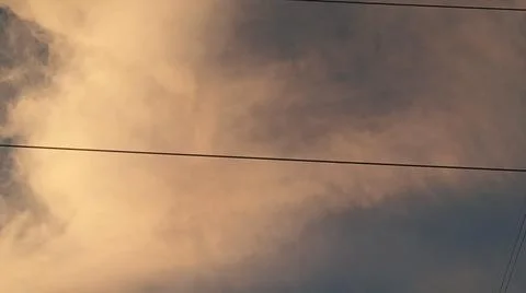 Dramatic sunset clouds with electric transmission tower wire. Stock Photos