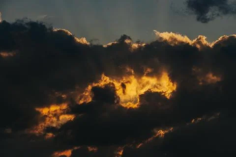 Dramatic sunset clouds with golden light illuminating dark storm clouds aga.. Stock Photos