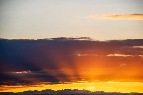 Dramatic sunset clouds with golden light rays Stock Photos