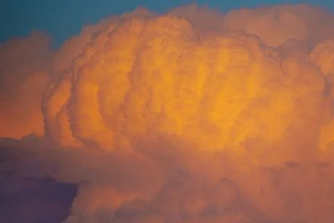 Dramatic sunset clouds illuminated in shades of orange and yellow against a.. 스톡 사진