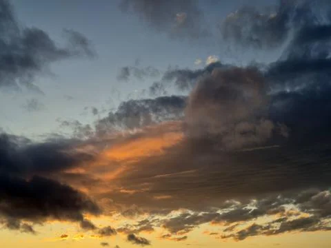 Dramatic sunset clouds over dark mountains Stock Photos
