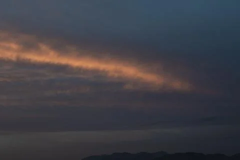 Dramatic Sunset Clouds Over Distant Mountains Stock Photos