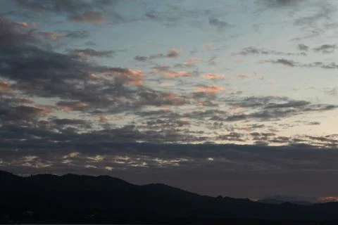 Dramatic Sunset Clouds Over Mountain Silhouettes Stock Photos