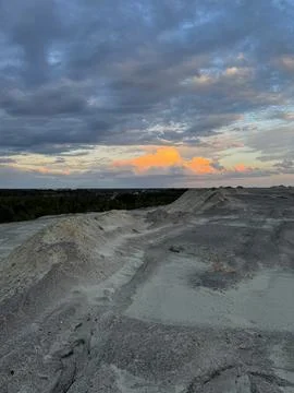 Dramatic sunset clouds over rugged sandy terrain Stock Photos