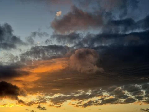 Dramatic sunset clouds over sky with golden and blue tones Stock Photos
