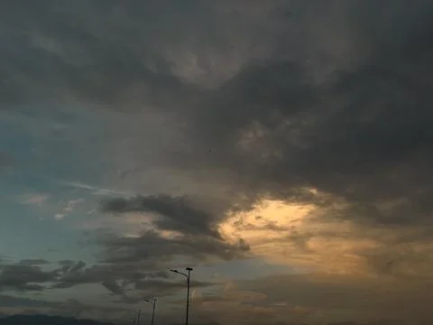 Dramatic Sunset Clouds Over Street Lamps Stock Photos
