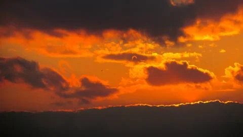 Dramatic sunset clouds painted in fiery orange hues marking the end of the da Stock Photos