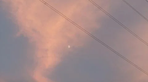 Dramatic sunset clouds with power lines and electrical cables in the evening sky Stock Photos
