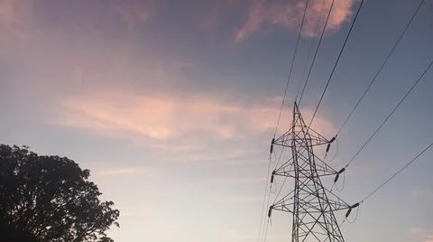 Dramatic sunset clouds with power lines and electrical cables in the evening sky Stock Photos
