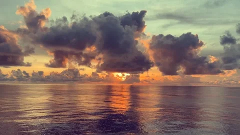 Dramatic sunset clouds reflect on the calm ocean surface creating a beautif.. 動画素材 338282731