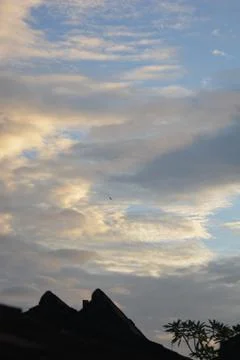 Dramatic sunset clouds with rooftop silhouette and copy space Stock Photos