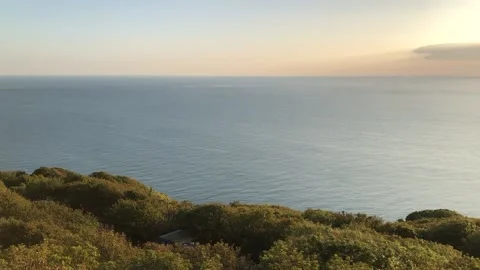 Dramatic sunset with clouds at the sea on a magic hour pan Stock Footage 160699902