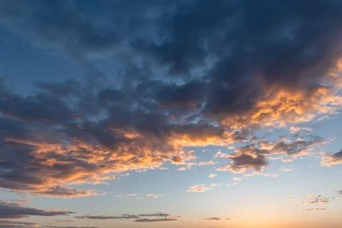 Dramatic sunset clouds stretch across a tranquil horizon, glowing with warm.. Stock Photos