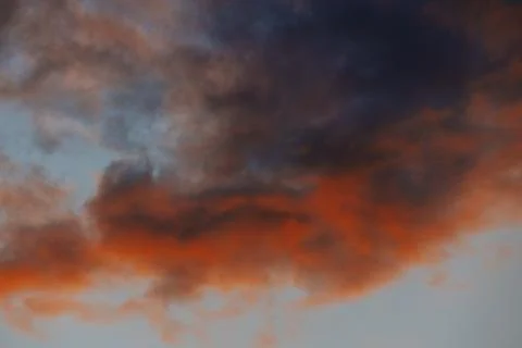 Dramatic sunset clouds with vibrant orange and dark blue hues creating a st.. Stock Photos