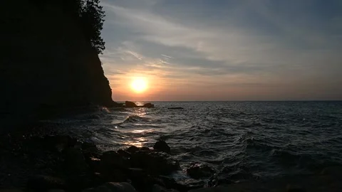 Dramatic sunset colors at sea. Waves hit the rocky shore and flysch cliff Stock Footage 139223174