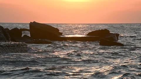 Dramatic sunset colors at sea. Waves hit the rocky shore and flysch cliff Stock Footage 139223392