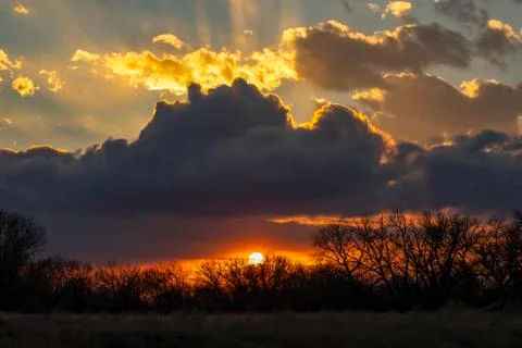 Dramatic sunset with dark and glowing clouds Stock Photos
