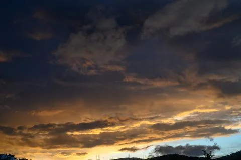 Dramatic Sunset with Dark and Golden Clouds Over Horizon, Deep Blue to Warm.. Foto stock