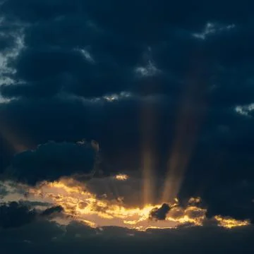 Dramatic sunset with dark clouds and glimpses of light. 写真素材