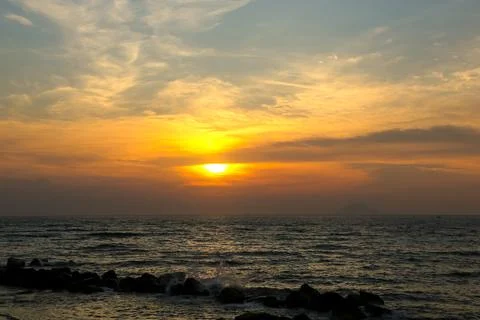 Dramatic sunset in dark clouds over the sea. Stock Photos