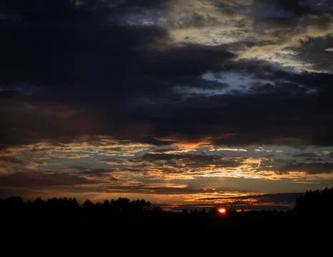 Dramatic Sunset with Dark Clouds Over the Horizon Stock Photos