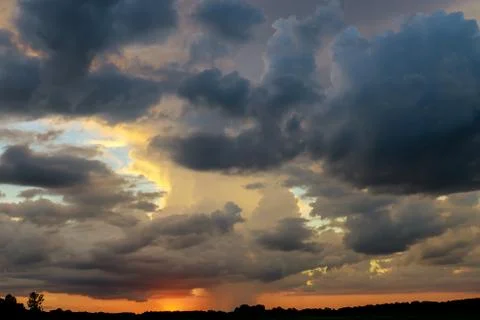 Dramatic sunset with dark clouds, rain, tornado or hurricane. Stock Photos