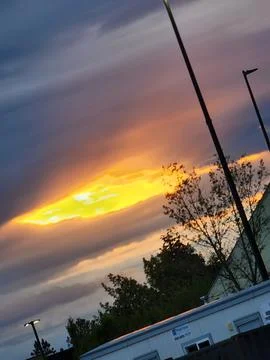 Dramatic Sunset with Fiery Clouds Over Suburb Stock Photos