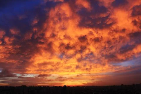 Dramatic sunset like fire in the sky with golden clouds. Stock Photos