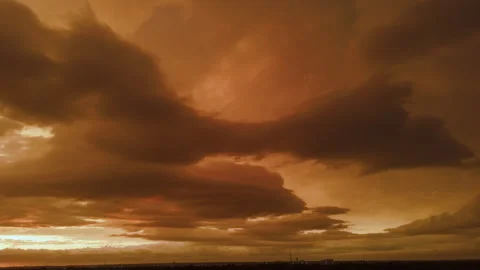Dramatic sunset with glowing golden clouds stretching across the evening sky Stockbeeldmateriaal 346790700
