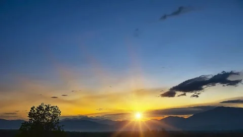 Dramatic Sunset Landscape with Silhouetted Trees and Clouds Stock Footage 310378509