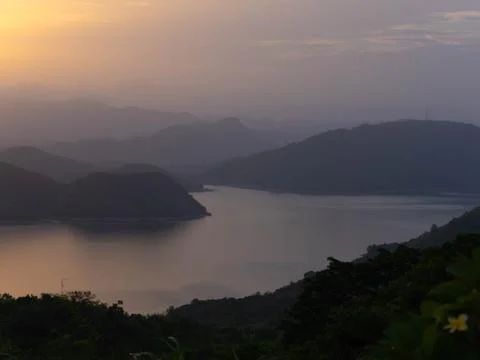 Dramatic sunset landscape view over a tranquil lake surrounded by mountain range Stock Photos