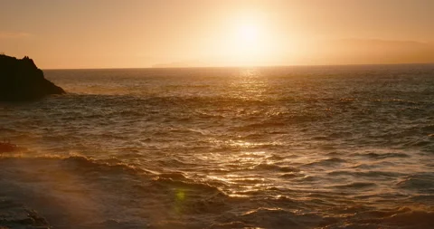 Dramatic sunset light reflected on ocean waves at rocky coastlinet. Golden hour Video stock 238855729