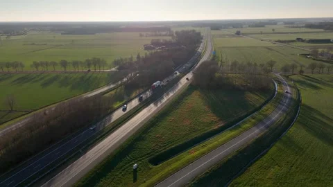 Dramatic Sunset Lighting Casts Long Shadows Over Twisting Rural Highway Bordered Stock Footage 325451912
