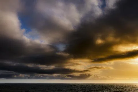Dramatic sunset lighting over the ocean with vibrant clouds Fotos de archivo