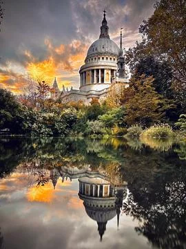 Dramatic sunset lights the dome of St Pauls Cathedral, framed by autumn trees Fotos Stock