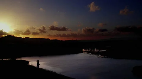Dramatic sunset with mountain silhouettes over lake Stock Footage