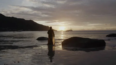 Dramatic sunset on the Ocean coast. A slender girl runs closer to the water Stock Footage 140666387
