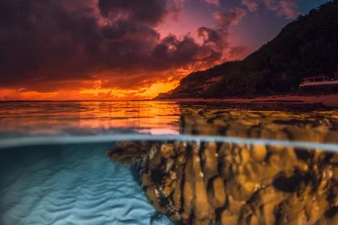 Dramatic sunset or sunrise over calm ocean with underwater sand patterns an.. Stock Photos