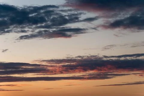 Dramatic sunset with orange clouds. Beautiful sky with multicolored cloudscape Stock Photos