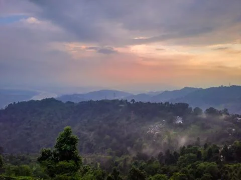 Dramatic sunset orange sky over mountain range and green forest at evening fr Fotos de archivo