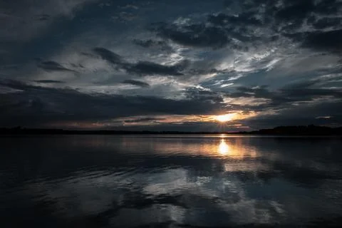 Dramatic Sunset Over a Calm Lake with Stunning Reflections Stock Photos