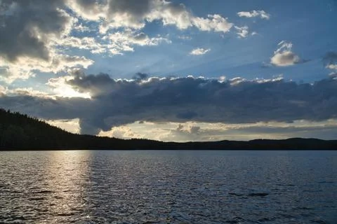 Dramatic Sunset Over Calm Lake and Wooded Hill, in sweden, smaland. Stock Photos